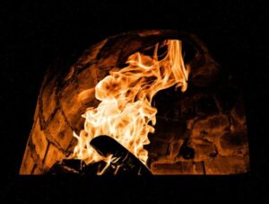 a fire burning inside of a brick oven