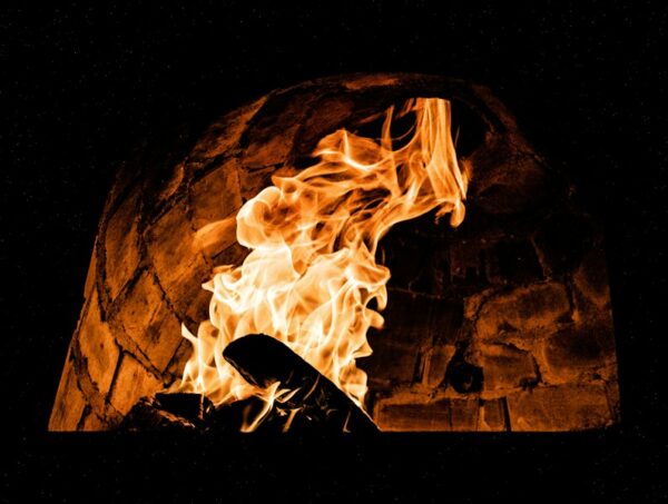 a fire burning inside of a brick oven
